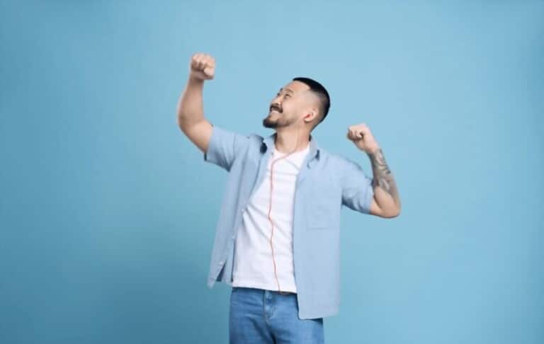 A happy man is wearing a white T-shirt and blue shirt