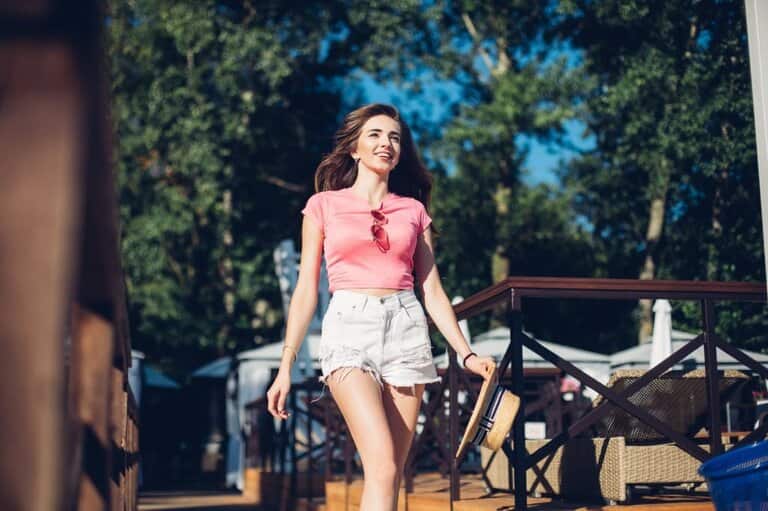 a girl wearing pink croptop shirt and high-waisted white shorts