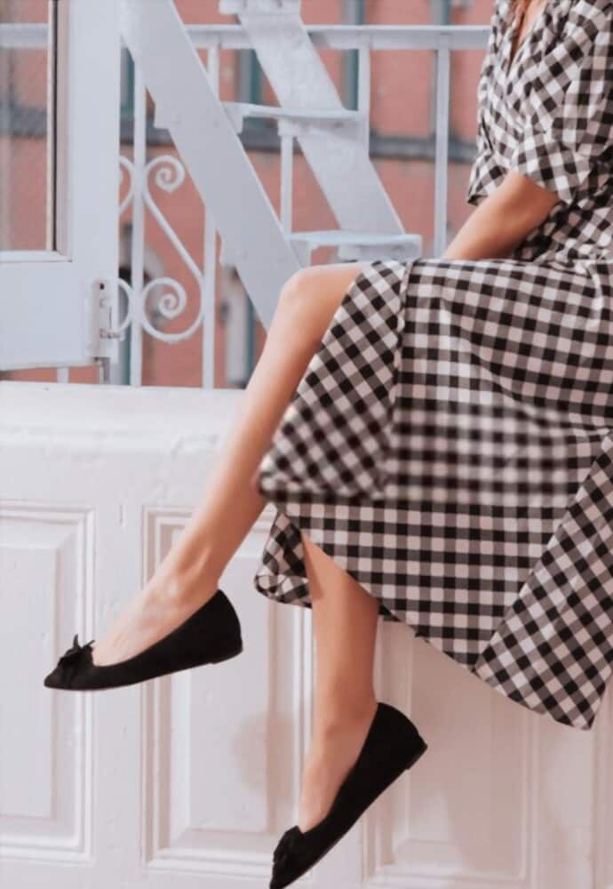 women with gingham dress sitting window