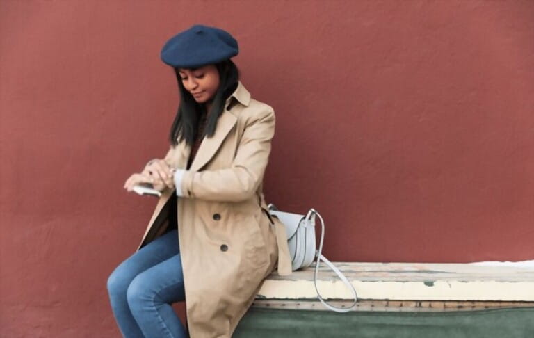 young women with colored trench coat sitting with red background young women with colored trench coat sitting with red background