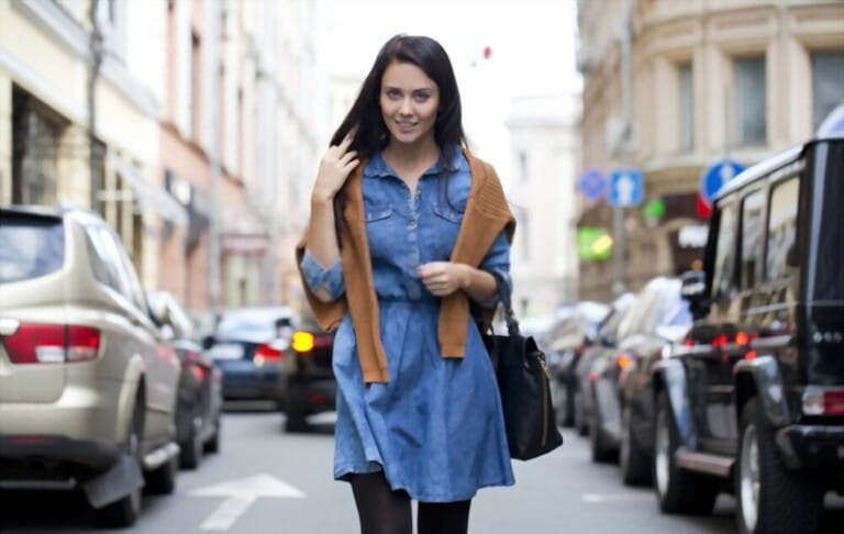 Beautiful young woman walking on the street with denim dress and jacket