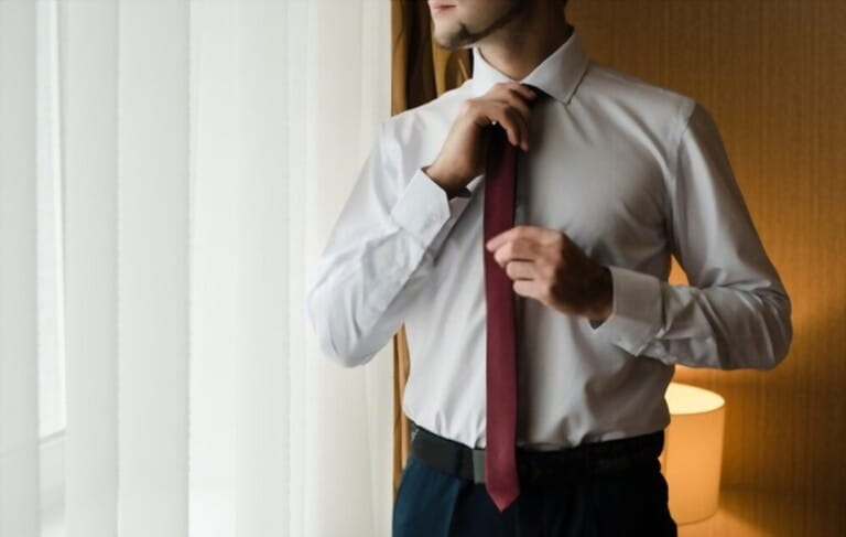 the groom straightens his tie, man in a tie, The morning of the groom, bridegroom's fees, fiance in shirt, claret tie