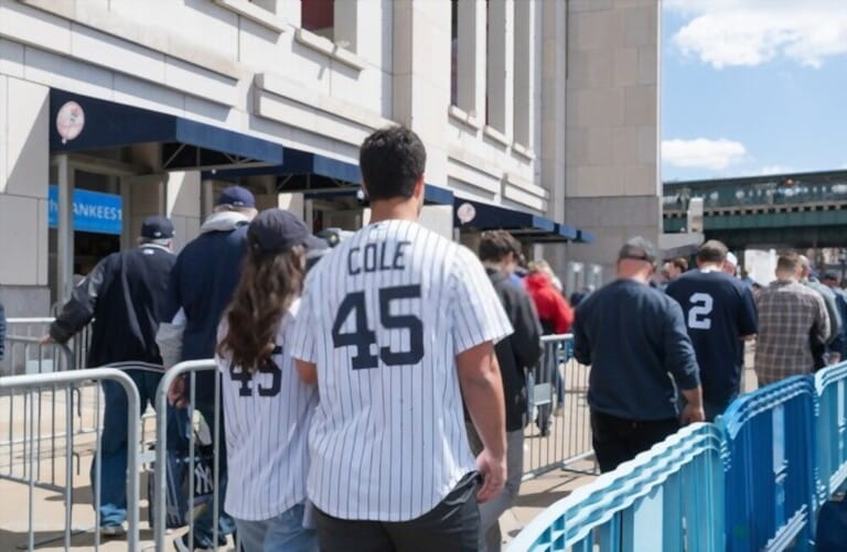 baseball fan couple wearing jerseys cheering for the baseball team walking in the crowd