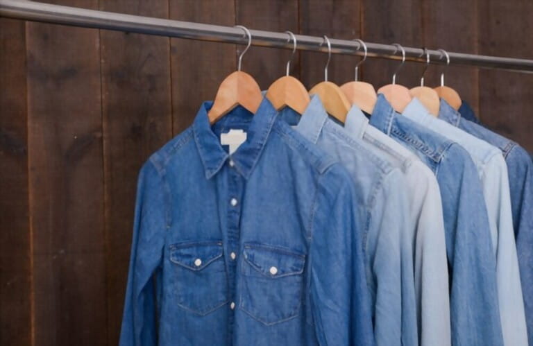 stylish denim shirt hanging on hook with wooden background