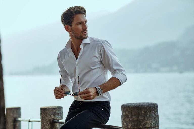 Stylish man in white vintage shirt, looking at mountain scenery