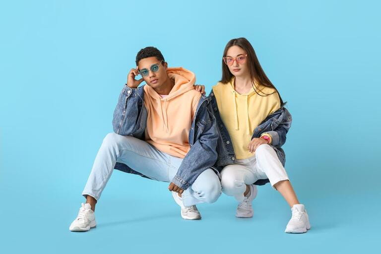 Stylish young couple in hoodies on blue background Stylish young couple in hoodies on blue background