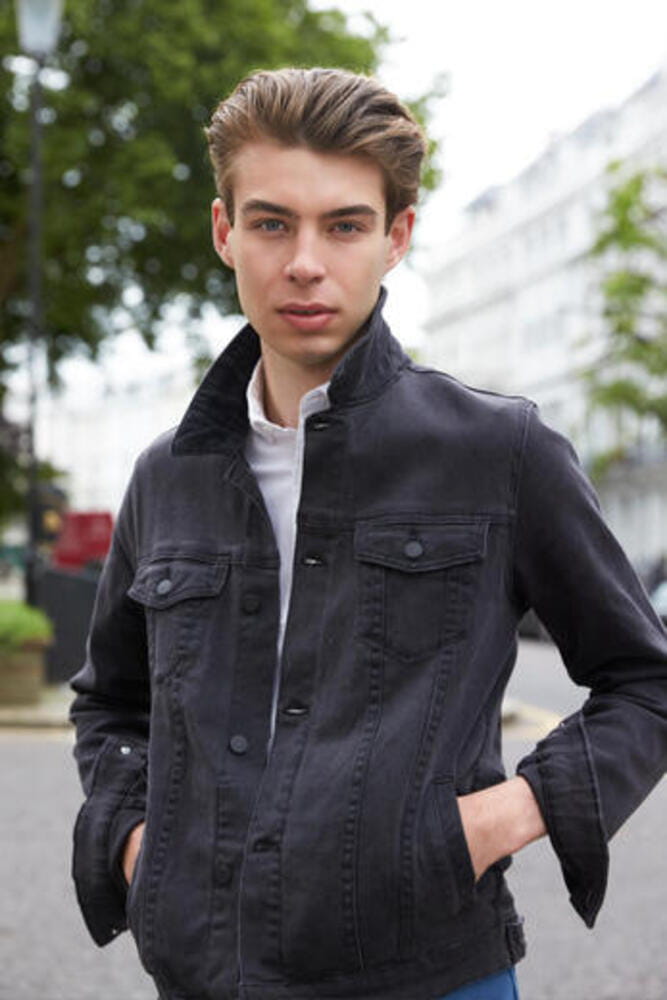 Young man in black denim jacket with hands in pockets