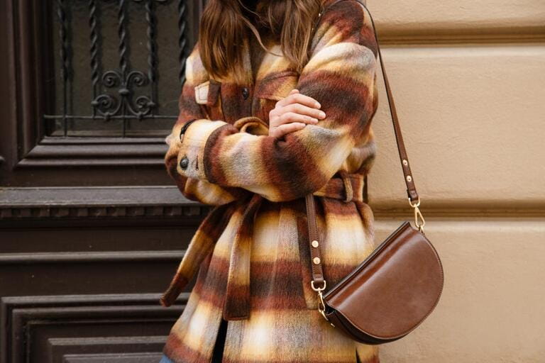 authentic street style portrait of an attractive woman wearing plaid check jacket coat, sunglasses and brown leather bag, crossing the street. fashion outfit details perfect for autumn fall winter authentic street style portrait of an attractive woman wearing plaid check jacket coat, sunglasses and brown leather bag, crossing the street. fashion outfit details perfect for autumn fall winter