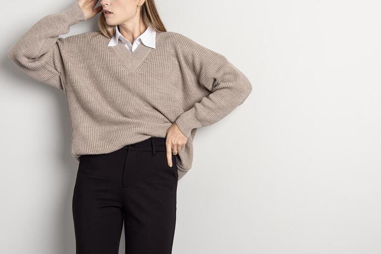 Woman in knitted woolen sweatshirt and black pants on white background. Woman in knitted woolen sweatshirt and black pants on white background.