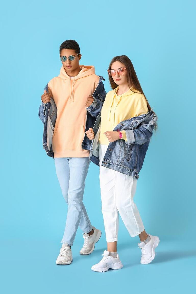 Stylish young couple in hoodies on blue background Stylish young couple in hoodies on blue background