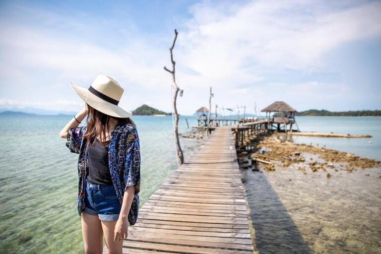 Asian women standing on pier wooden bridge at Ao Pra beach, Koh Mak island, Trat, Thailand Asian women standing on pier wooden bridge at Ao Pra beach, Koh Mak island, Trat, Thailand