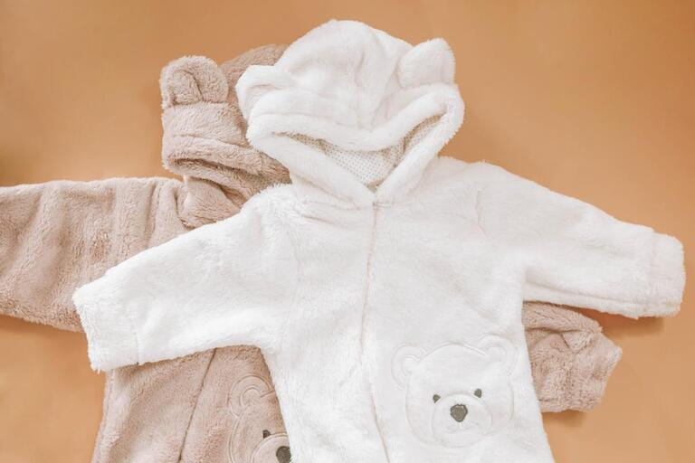Jumpsuits for newborns in the shape of bears on a beige background. Clothes for kids
