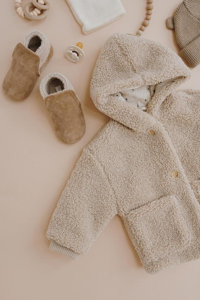 Flatlay aesthetic Scandinavian baby clothes, accessories, toys collage on neutral pastel beige background. Trendy elegant neutral colour warm winter children's stuff. Flatlay aesthetic Scandinavian baby clothes, accessories, toys collage on neutral pastel beige background. Trendy elegant neutral colour warm winter children's stuff.