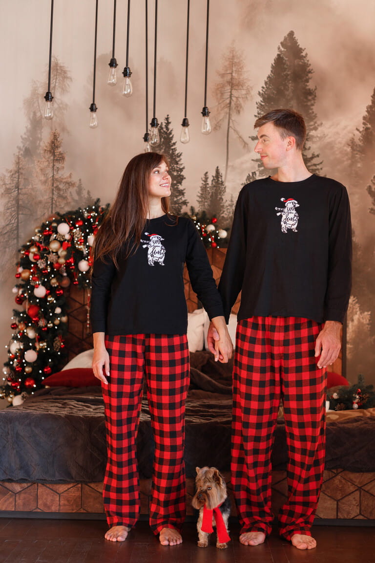 couple with cute dog in christmas pajamas at home at christmas