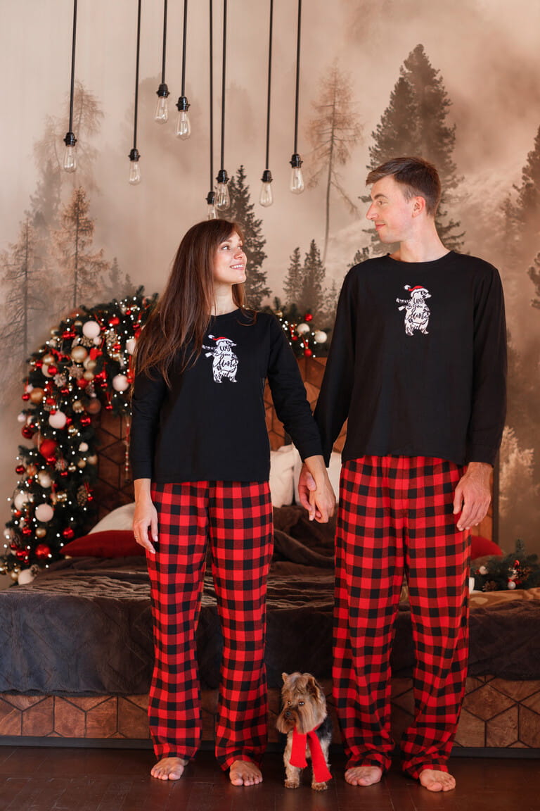 couple with cute dog in christmas pajamas at home at christmas couple with cute dog in christmas pajamas at home at christmas