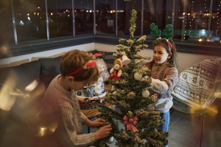 Happy children decorate the Christmas tree