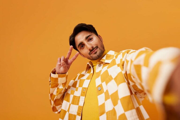Young man with vitiligo gesturing peace sign