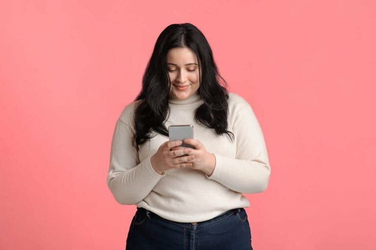 Plus size woman holding smartphone in hand, texting or reading messages Plus size woman holding smartphone in hand, texting or reading messages