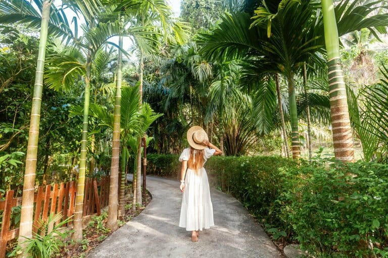 Happy tourist in white dress and straw hat