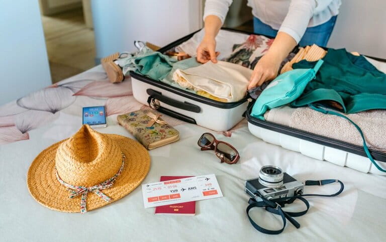 Unrecognizable woman prepares suitcase for summer vacation