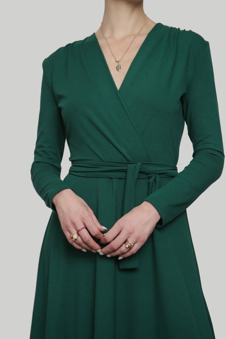 Serie of studio photos of young female model in emerald green wrap dress. Serie of studio photos of young female model in emerald green wrap dress.