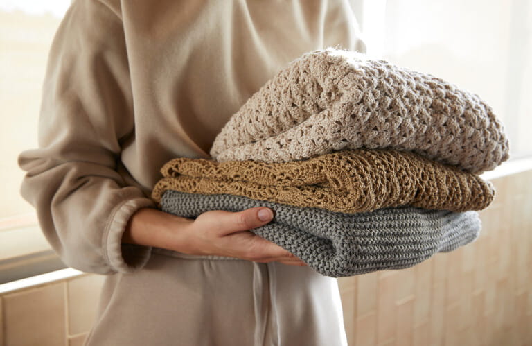Hand holding a stack of sustainable cloths in tracksuit, homemade and Eco friendly fabric