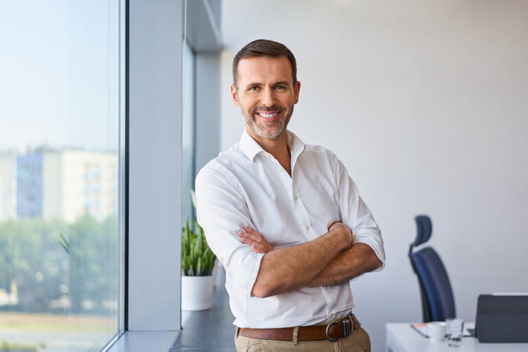 Portrait of smiling mid adult businessman standing at corporate office Portrait of smiling mid adult businessman standing at corporate office