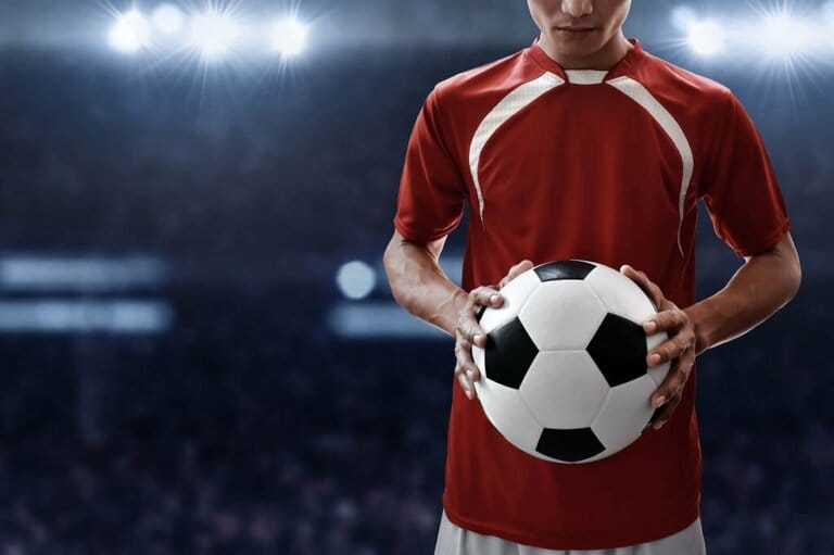 Soccer player holding soccer ball Soccer player holding soccer ball