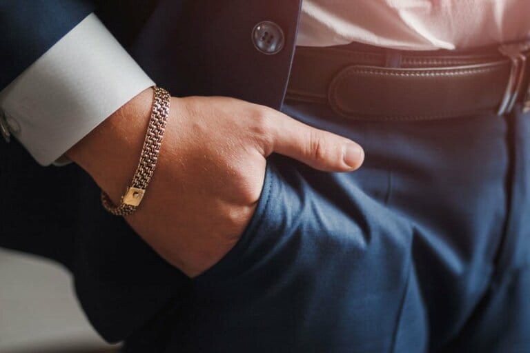 Body detail of a businessman. Close-up of hand with jewelry necklace in pocket