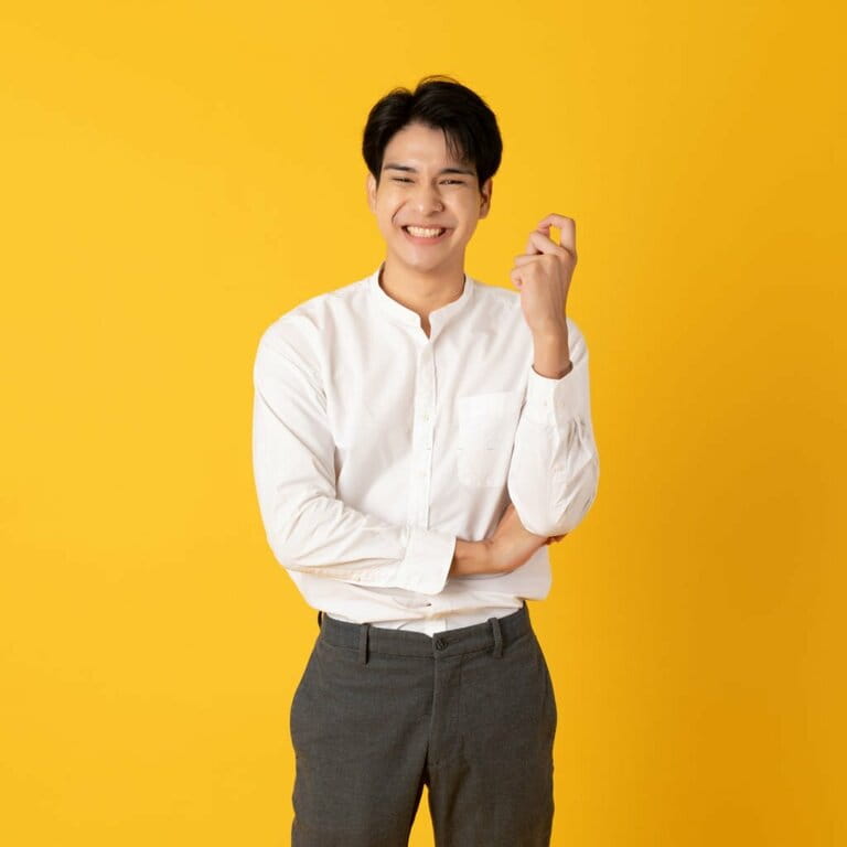 Handsome Asian teenage man with laughter isolated on yellow background Handsome Asian teenage man with laughter isolated on yellow background