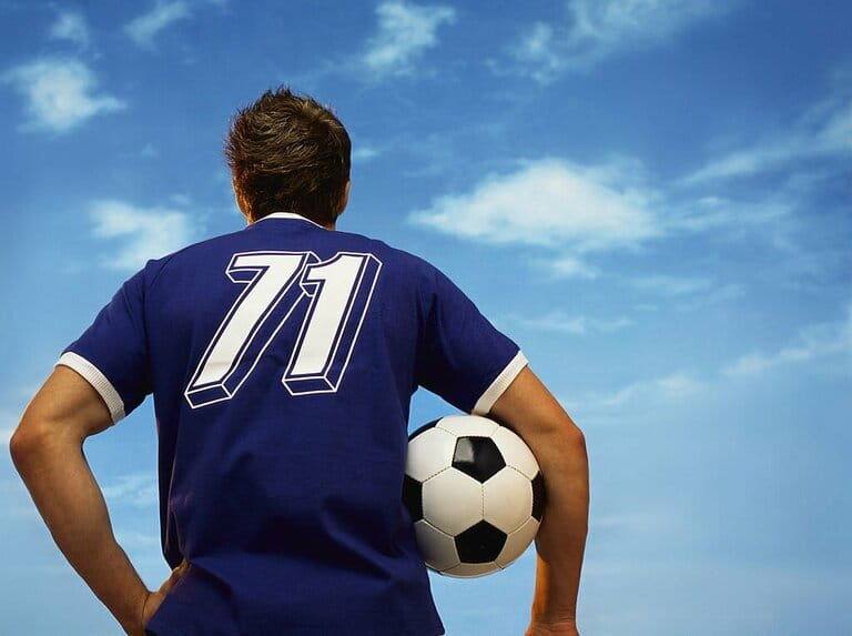 Rear View of a Football Player Holding a Football Rear View of a Football Player Holding a Football