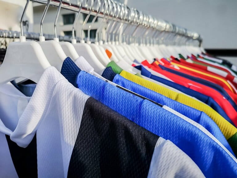 Colorful sports team shirts hang on clothes rails Colorful sports team shirts hang on clothes rails