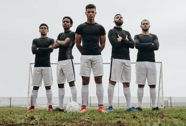 Soccer players standing next to each other on the soccer field Soccer players standing next to each other on the soccer field
