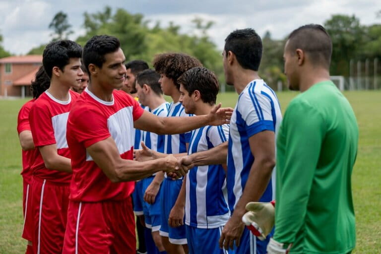 Soccer players shake hands with their opponents before the match