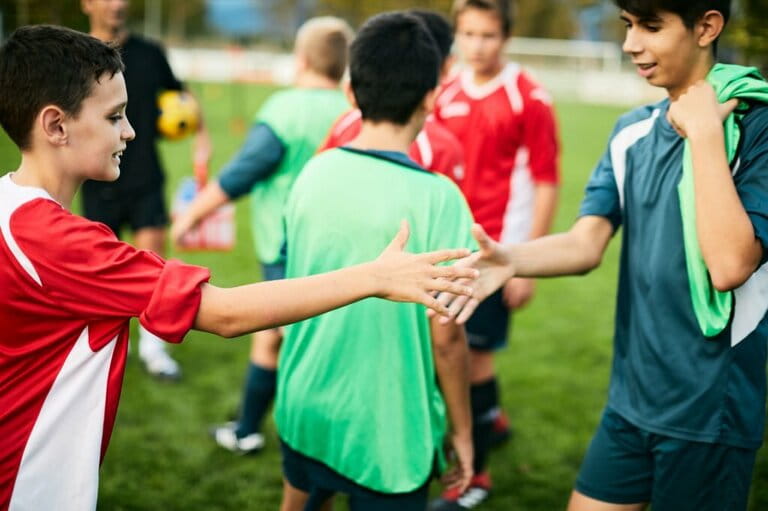 Two teenage soccer players greet each other after the match.