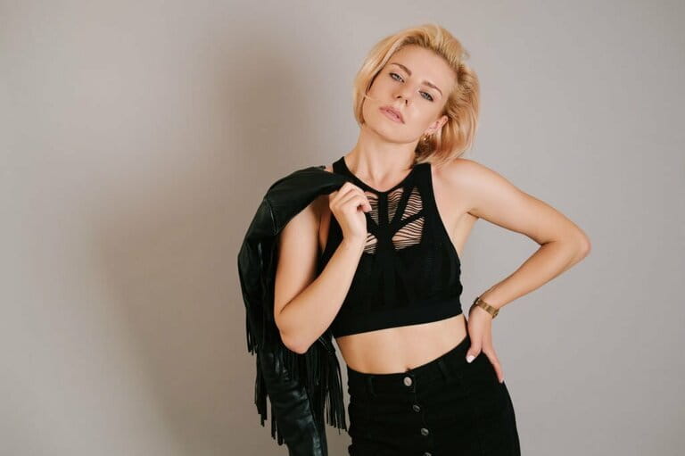 Young woman in black clothes with jacket over shoulder Young woman in black clothes with jacket over shoulder