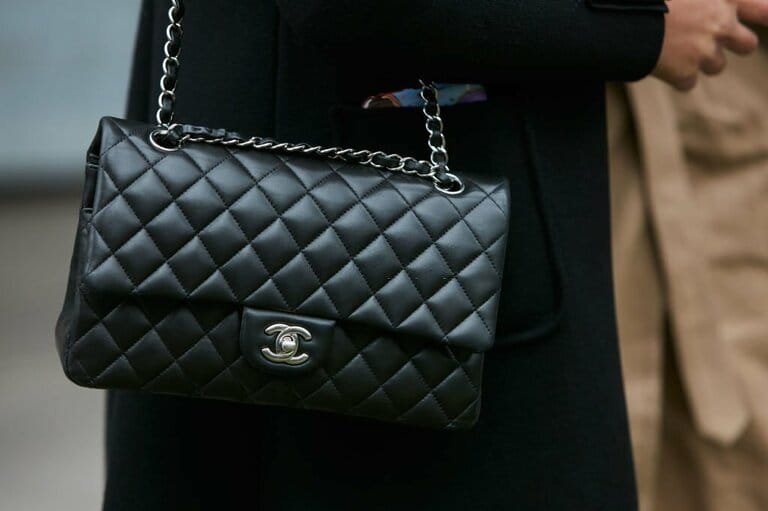 Woman with black Chanel leather bag with silver chain Woman with black Chanel leather bag with silver chain