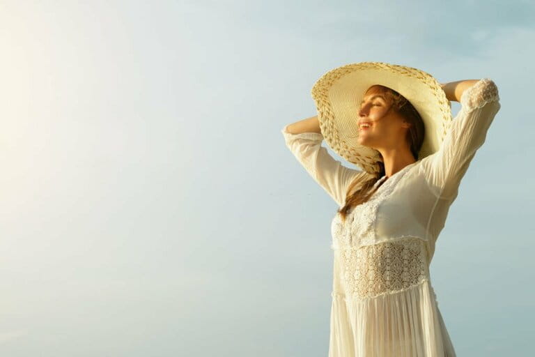 Portrait of beautiful young woman with wide brimmed hat on the beach Portrait of beautiful young woman with wide brimmed hat on the beach