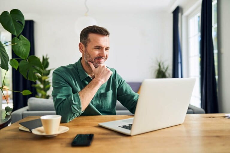 Mature businessman working from home using laptop 