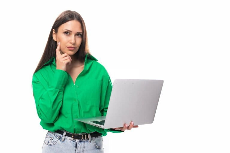 Portrait of a cute slim happy brown haired brown eyes woman wearing a green shirt working with a laptop. Concept of working online