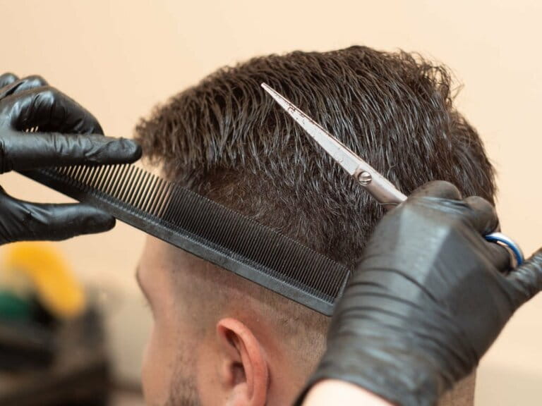 Stylist works with hairdressing clients, close-ups. The master cuts hair with scissors and comb. Stylist works in a hair salon. Selective soft focus. Blurred background