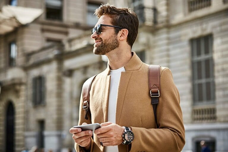 Smiling businessman holding phone and looking away Smiling businessman holding phone and looking away