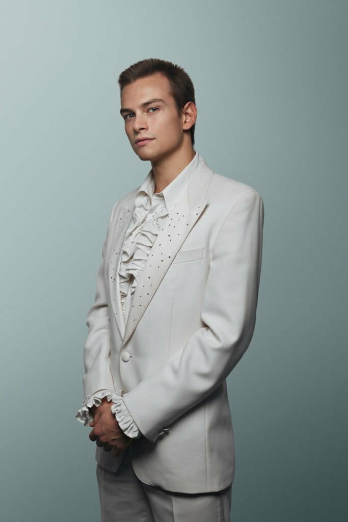 Young man wearing 70' white suit and puffy shirt Young man wearing 70' white suit and puffy shirt