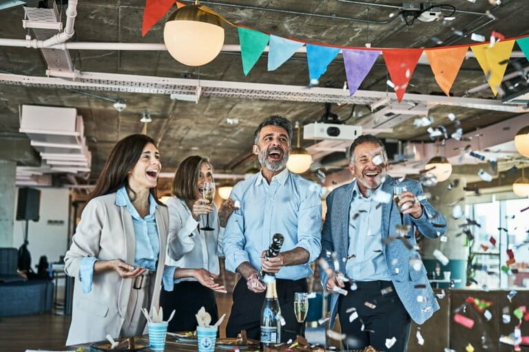 Business people celebrating with party popper in office 