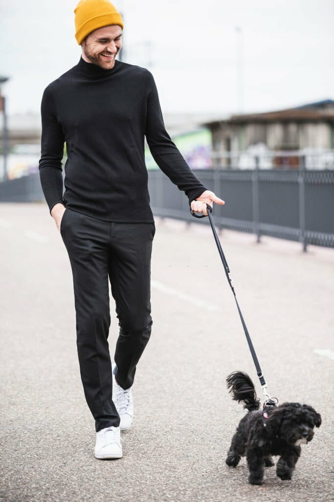 Fashionable young man walking with dog on a bridge Fashionable young man walking with dog on a bridge
