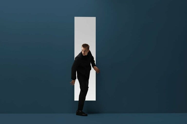 Man walking threw rectangular opening in coloured room Man walking threw rectangular opening in coloured room