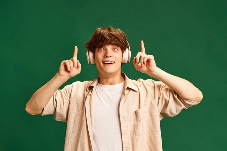 Portrait of cheerful handsome man standing raising his hand and indicating that he has a new idea or answer on green studio background Portrait of cheerful handsome man standing raising his hand and indicating that he has a new idea or answer on green studio background