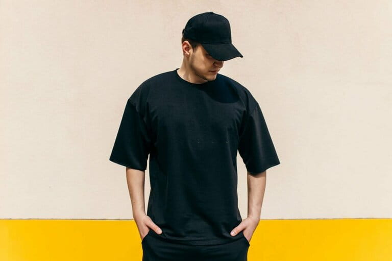 Man wearing black white t-shirt and black baseball cap with space for your logo or design Man wearing black white t-shirt and black baseball cap with space for your logo or design