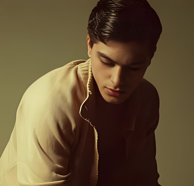 Male beauty concept. Portrait of fashionable young man with stylish haircut wearing trendy cardigan & posing over mustard background. Male beauty concept. Portrait of fashionable young man with stylish haircut wearing trendy cardigan & posing over mustard background.