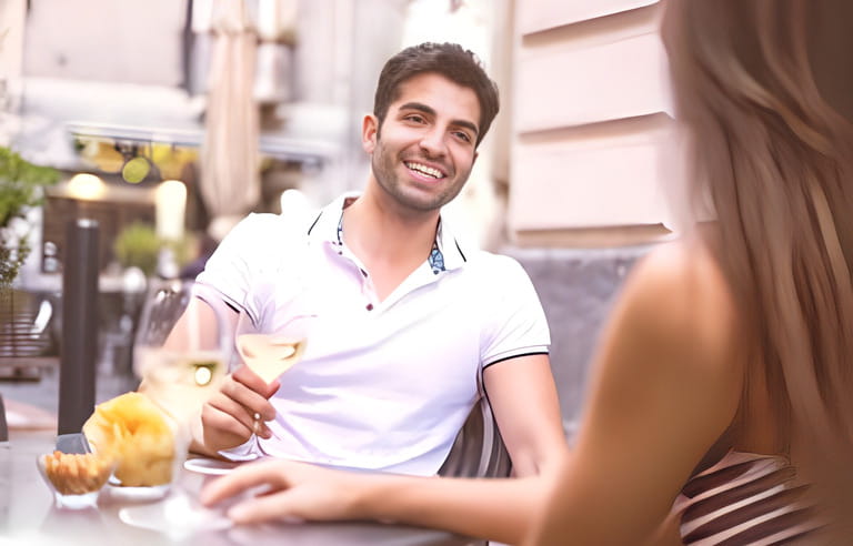 Young couple drinking white wine in an outdoors wine bar